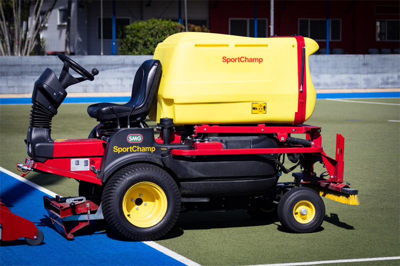 SMG SportChamp turf cleaning machine parked on a blue and green hockey field